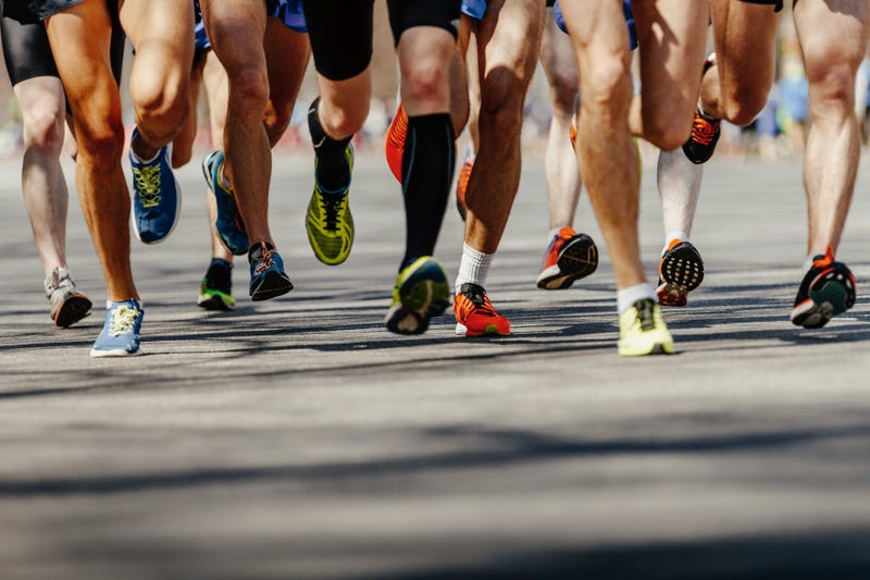 legs group men runners running on asphalt road