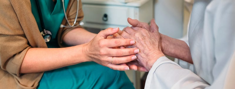 Doctor giving encouragement to elderly patient - stock photo