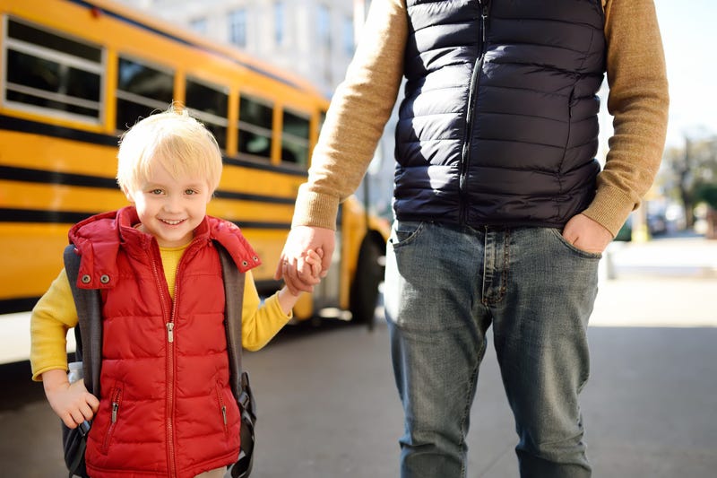 kid with father in front of school bus