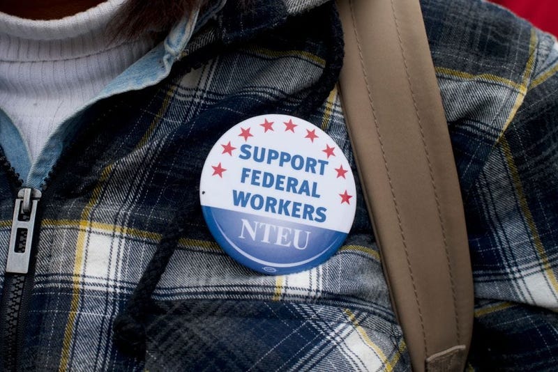 A woman wears a National Treasury Employees Union pin stating "SUPPORT FEDERAL WORKERS" while joining area elected officials and furloughed federal workers at a rally in front of Independence Hall on Jan. 8, 2019.