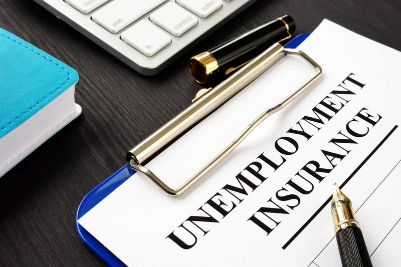 Unemployment insurance form and clipboard on a desk.