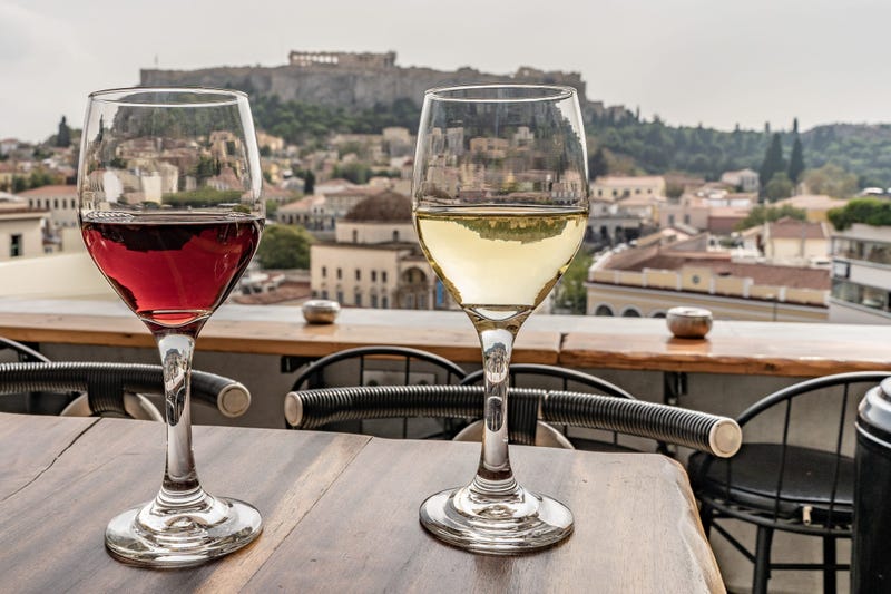 Glasses of wine with a view of the Acropolis in Athens, Greece. 