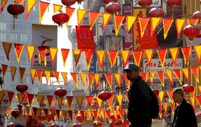 edestrians walk by red and yellow banners that are strung across Grant Street for Chinese New Year in San Francisco's Chinatown district on February 3, 2011 