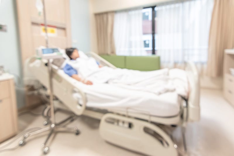 A blurry image of a hospital patient lying in bed.