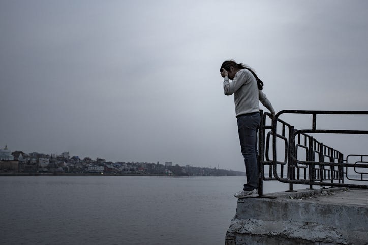 Depressed sad frustrated man stands on the edge of the bridge to jump.