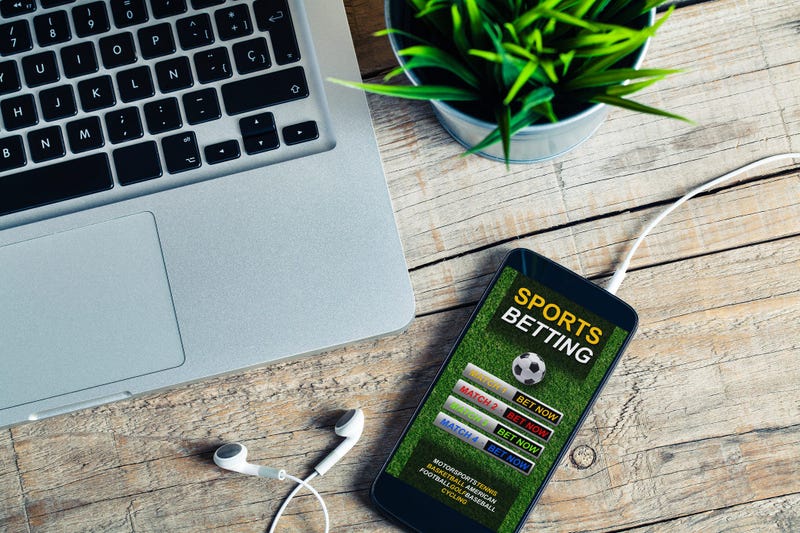 Mobile phone at the office with sports betting website in the screen, placed at the office.