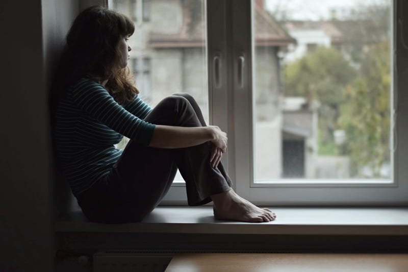 Anxious woman looks out of the window