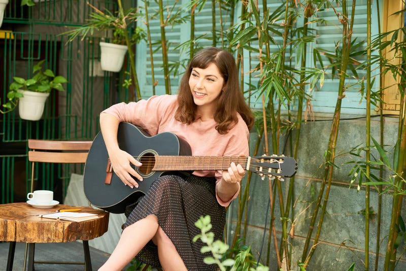woman on front porch with guitar