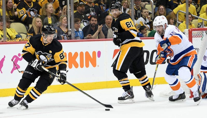 Sidney Crosby #87 of the Pittsburgh Penguins controls the puck against Cal Clutterbuck #15 of the New York Islanders