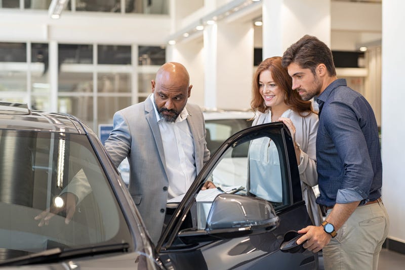 couple looking at a new car in a showroom