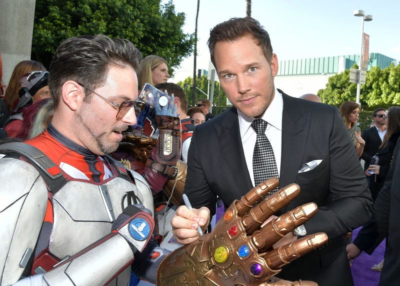 Chris Pratt signs a Thanos gauntlet replica worn by an Iron Man lookalike at the premiere of Avengers: EndGame