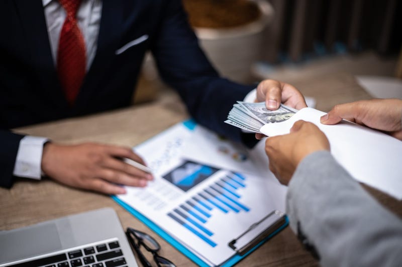 usinessman giving bribe money to partner in a corruption scam 