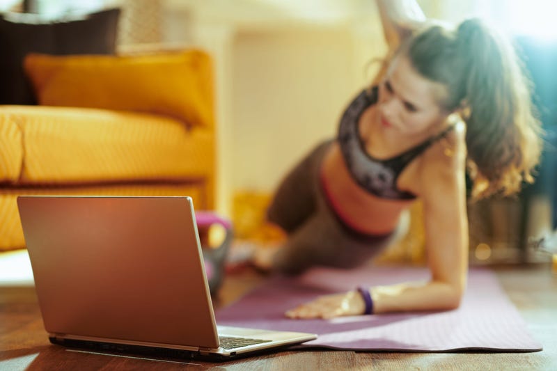 Woman exercising with online instruction