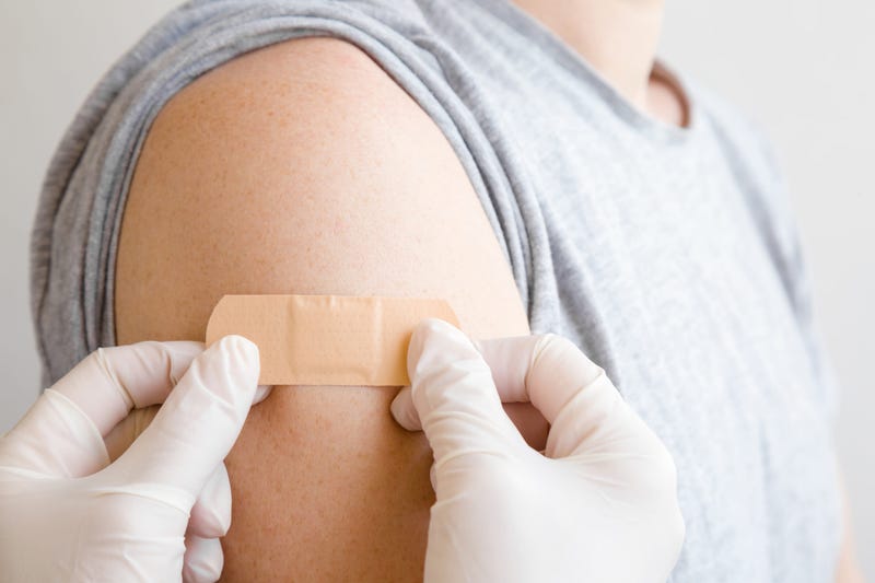 Doctor places band aid on arm after vaccination