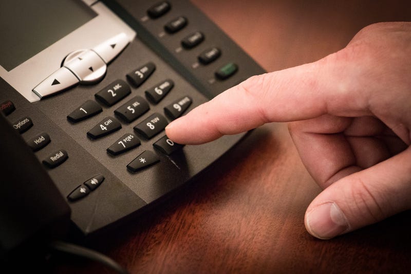 Finger dialing phone call on touch tone telephone.