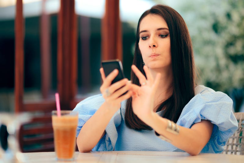 Woman Holding Phone Confused