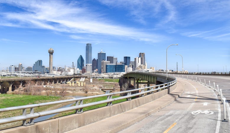 Wide shot of Highway Overpass with Trinity River and Skyline of Downtown Dallas in the Distance on a Clear Summer Day - Dallas, Texas, USA