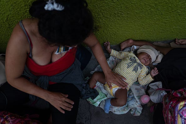 A Honduran migrant and her baby take shelter on a sidewalk on June 19, 2019 in Tapachula, Mexico. Since shelters in the city are over capacity, many migrants are living on sidewalks while they wait for their appointments to obtain a humanitarian visa.