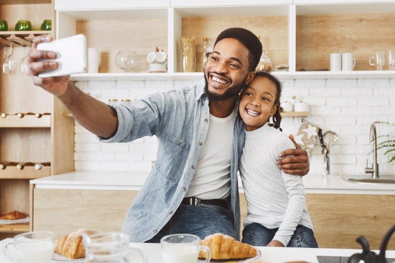 father and daughter taking a selfie in the kitchen