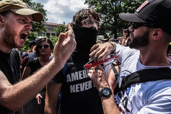 Left-wing protesters yell at Trump supporter