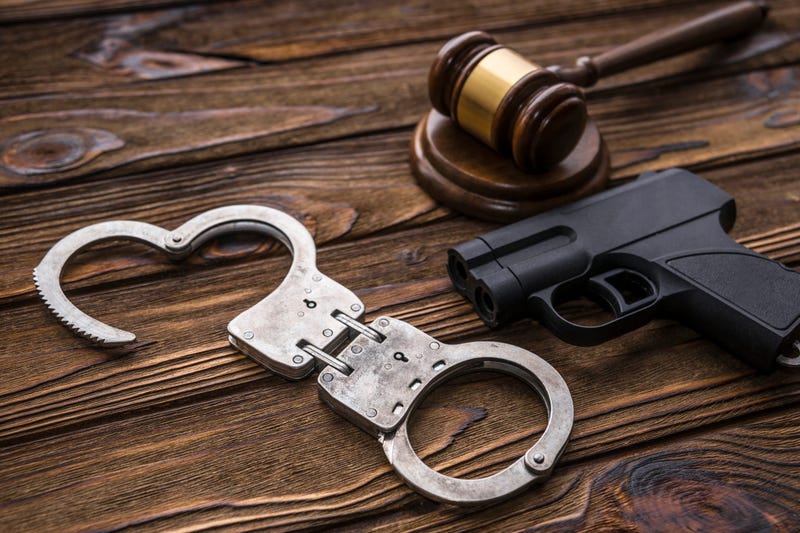 A gavel, gun and handcufffs