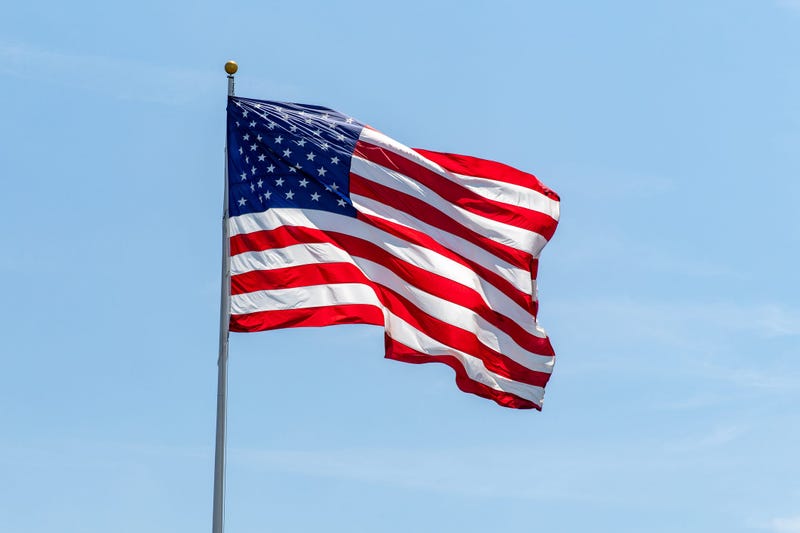 American flag waving on pole with bright vibrant red white and blue colors
