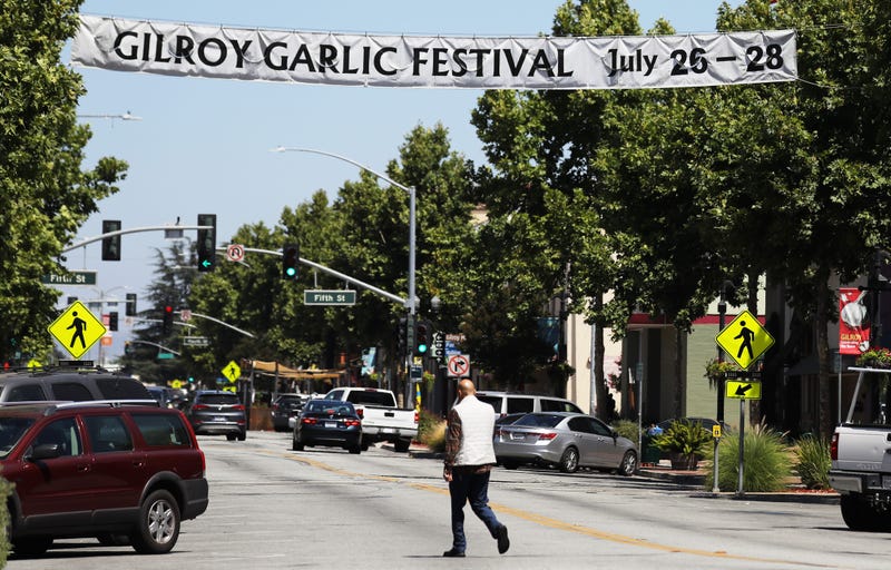A man walks beneath a sign advertising the nearby Gilroy Garlic Festival after a mass shooting took place at the event yesterday on July 29, 2019 in Gilroy, California.