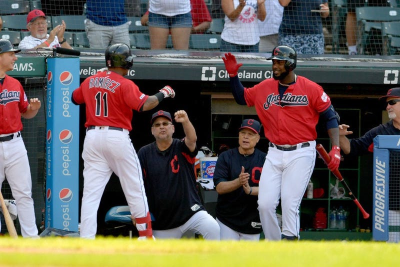 CLEVELAND, OHIO - AUGUST 07: Jose Ramirez #11 celebrates with Terry Francona #77 and Franmil Reyes #32 of the Cleveland Indians after Ramirez hit a solo homer during the second inning of game two of a double header against the against the Texas Rangers at