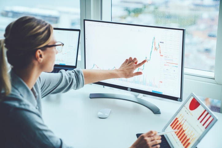 Woman looking at data on computer screens
