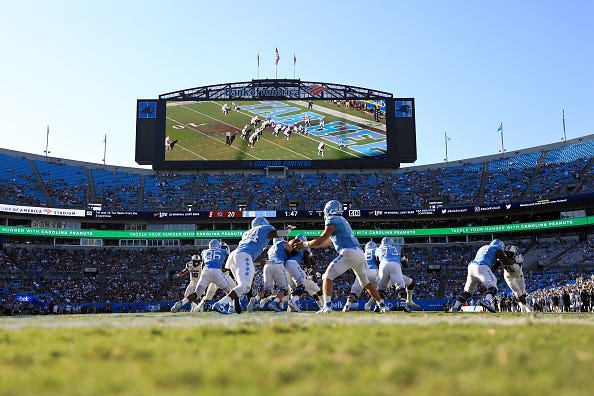 CHARLOTTE, NORTH CAROLINA - AUGUST 31: Sam Howell #7 of the North Carolina Tar Heels hands the ball off to teammate Antonio Williams #24 of the North Carolina Tar Heels during the Belk College Kickoff game at Bank of America Stadium on August 31, 2019 in