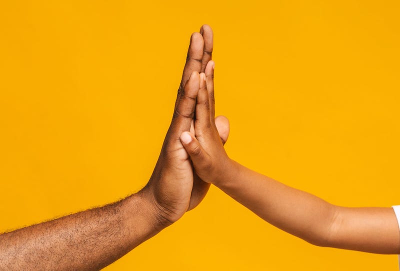 High five gesture of black father and child