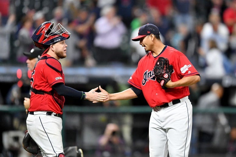 Catcher Roberto Perez #55 celebrates with closing pitcher Carlos Carrasco #59 of the Cleveland Indians
