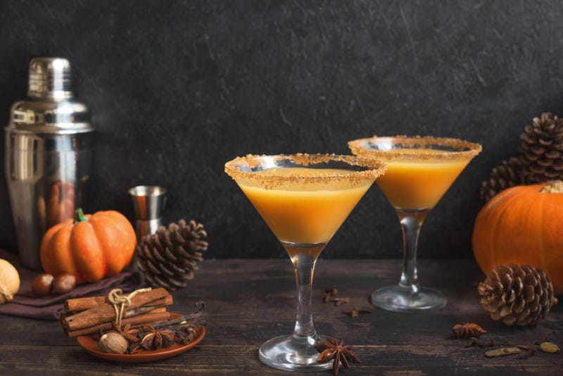 Pumpkintini. Pumpkin martini cocktail, homemade festive seasonal drink for Thanksgiving and Halloween party. Pumpkin pie spice cocktail and autumn decor.