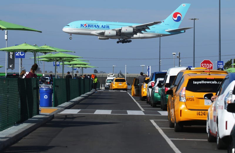 A Korean Air plane lands as taxis are lined up at the new 'LAX-it' ride-hail passenger pickup lot at Los Angeles International Airport (LAX) on November 6, 2019 in Los Angeles, California.