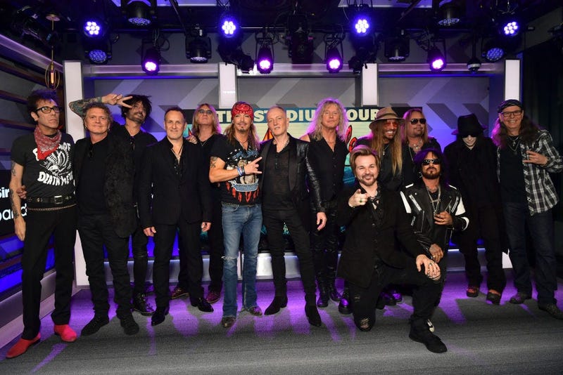 LOS ANGELES, CALIFORNIA - DECEMBER 04: (L-R) Slim Jim Phantom, Rick Allen, Tommy Lee, Vivian Campbell, Joe Elliott, Bret Michaels, Phil Collen, Rick Savage, Rikki Rockett, C.C. DeVille, Nikki Sixx, Vince Neil, Mick Mars, and Bobby Dall speak during the pr