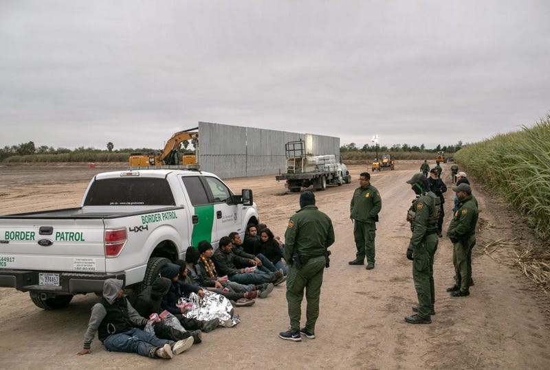 U.S. Border Patrol agents detain undocumented immigrants caught near a section of privately-built border wall under construction on December 11, 2019 near Mission, Texas.