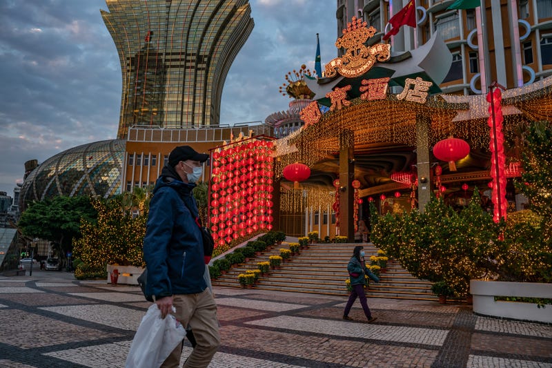 People wearing face masks walk in front of the Grand Lisboa Hotel on January 28, 2020 in Macau, China.