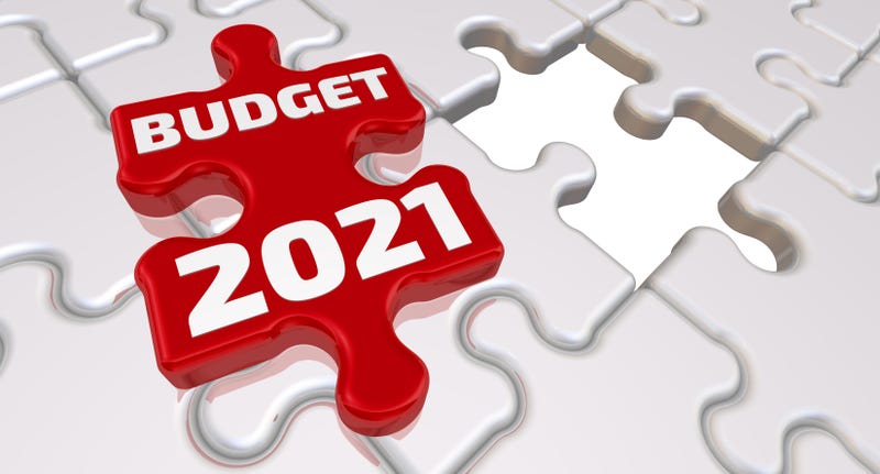 Folded white puzzles elements and one red with text BUDGET 2021