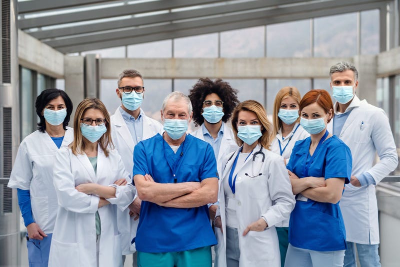 A group of doctors with face masks looking at camera,