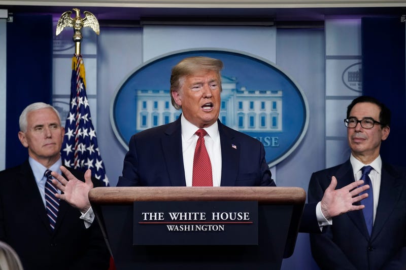  Flanked by Vice President Mike Pence (L) and Treasury Secretary Steven Mnuchin, U.S. President Donald Trump speaks during a briefing on the coronavirus pandemic, in the press briefing room of the White House on March 25, 2020