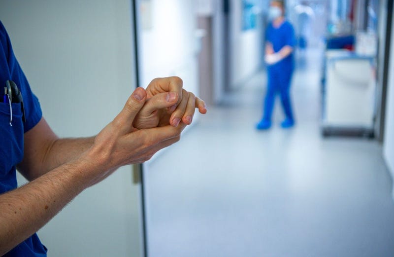 A medical staff wearing a protective mask and clothing cleans hands at the intensive care unit at the St. Josef Hospital on April 1, 2020 in Bochum, Germany. 