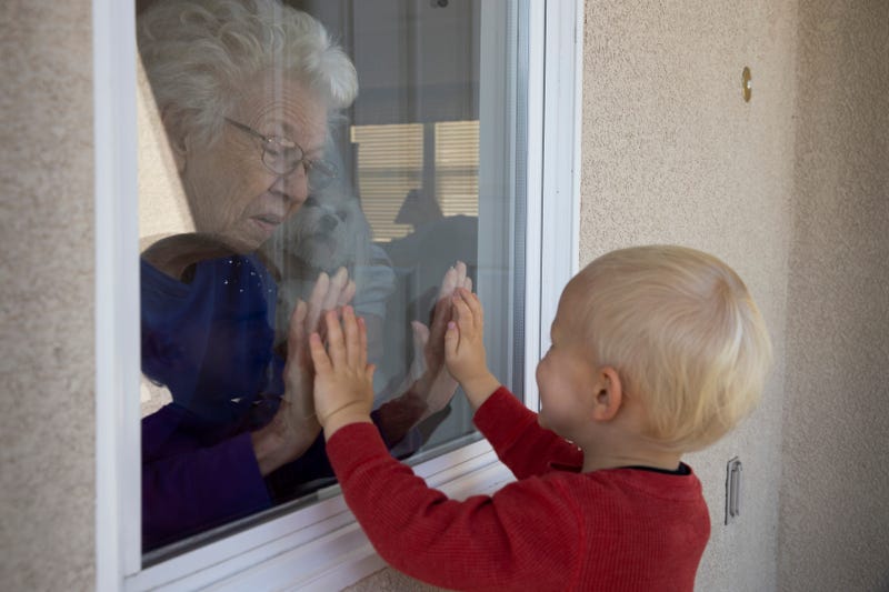 VENTURA, CA - APRIL 3: Mary-Lou McCullagh, 83, and her husband Bob, 84, greet Axel Stirton, 2, the little boy who lives across the street April 3, 2020 in Ventura, California.