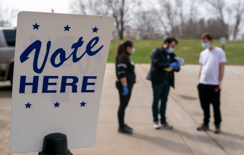 Poll worker Josh Harrison, center, works with Chad Donahue, right, during curbside voting on April 7, 2020 in Madison, Wisconsin. 