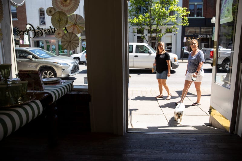 People walk between shops and restaurants that have reopened this week following loosening of non essential business restrictions on May 2, 2020 in Franklin, Tennessee