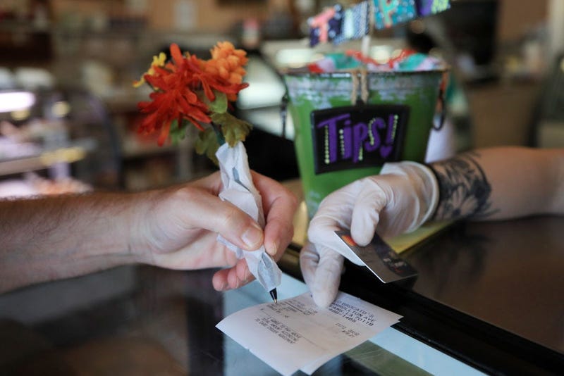 NEW ORLEANS, LA - MARCH 19: A patron uses a pen wrapped in paper to sign a credit card receipt at Angelo Brocato's Italian Ice Cream Parlor due to the coronavirus (COVID-19) 