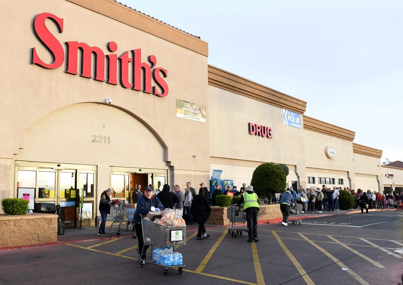 Shoppers leave with groceries as others wait for their turn to enter a Smith's Food & Drug store on March 20, 2020 in Las Vegas, Nevada.