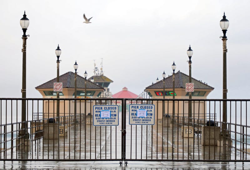 A sign explaining the closure of the Huntington Beach Pier is seen on March 24, 2020 in Huntington Beach.