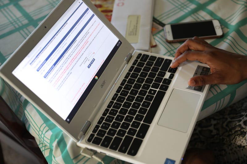 Jessie Morancy uses her computer to fill out the application for unemployment benefits after being laid off from her job at the Fort Lauderdale–Hollywood International Airport on March 27, 2020 in Hollywood, Florida.