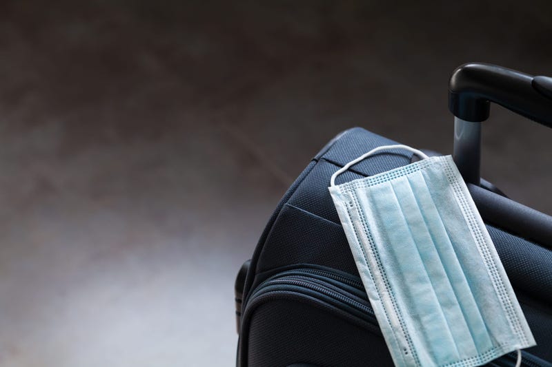 Travel suitcase and medical mask. The ban on travel during the epidemic of coronavirus and quarantine against corona virus or covid-19 concept.