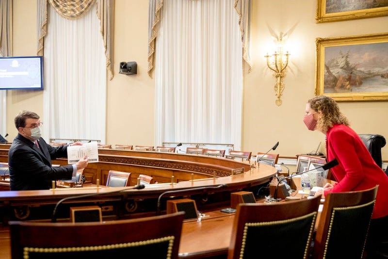Veterans Affairs Secretary Robert Wilkie, left, holds up a document titled Hydroxychloroquine Timeline and Utilization as he speaks with Chairwoman Rep. Debbie Wasserman Schultz (D-FL) during a House Appropriations Subcommittee hearing on Capitol Hill.